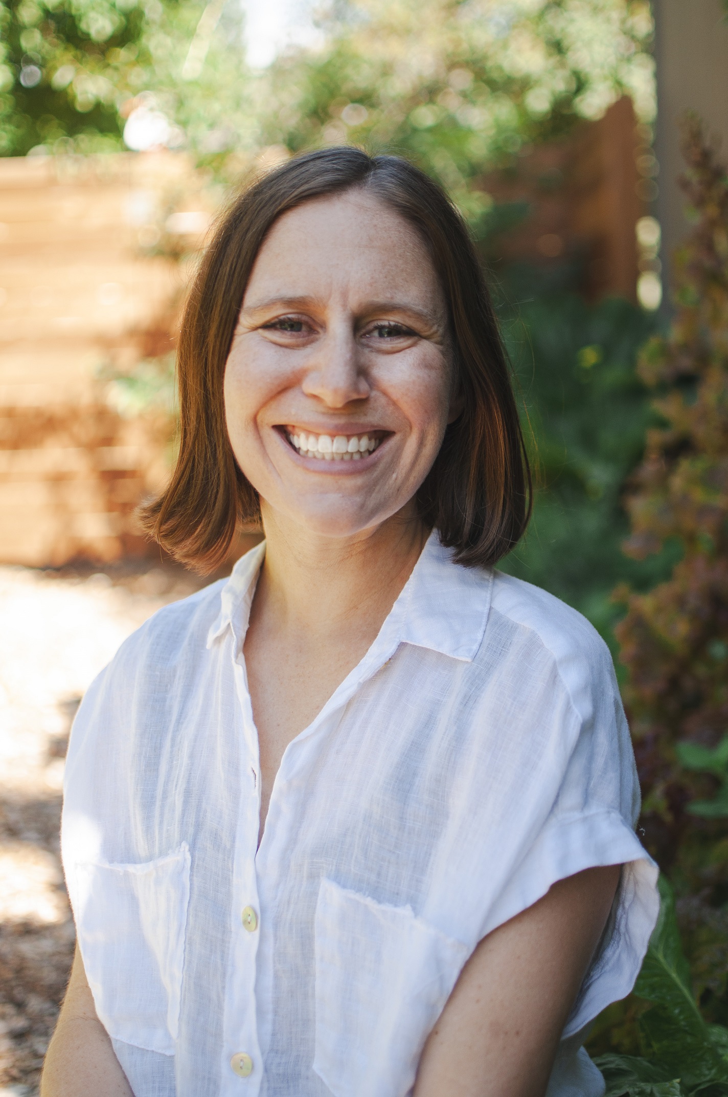Dr. Knerr is sitting facing the camera and smiling.